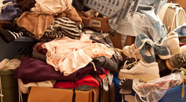 Residential hoarding scene with clothes and other items in big pile